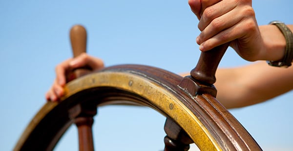 North Star Financial Services – About Hands on Ship Wheel with Blue Sky in Background